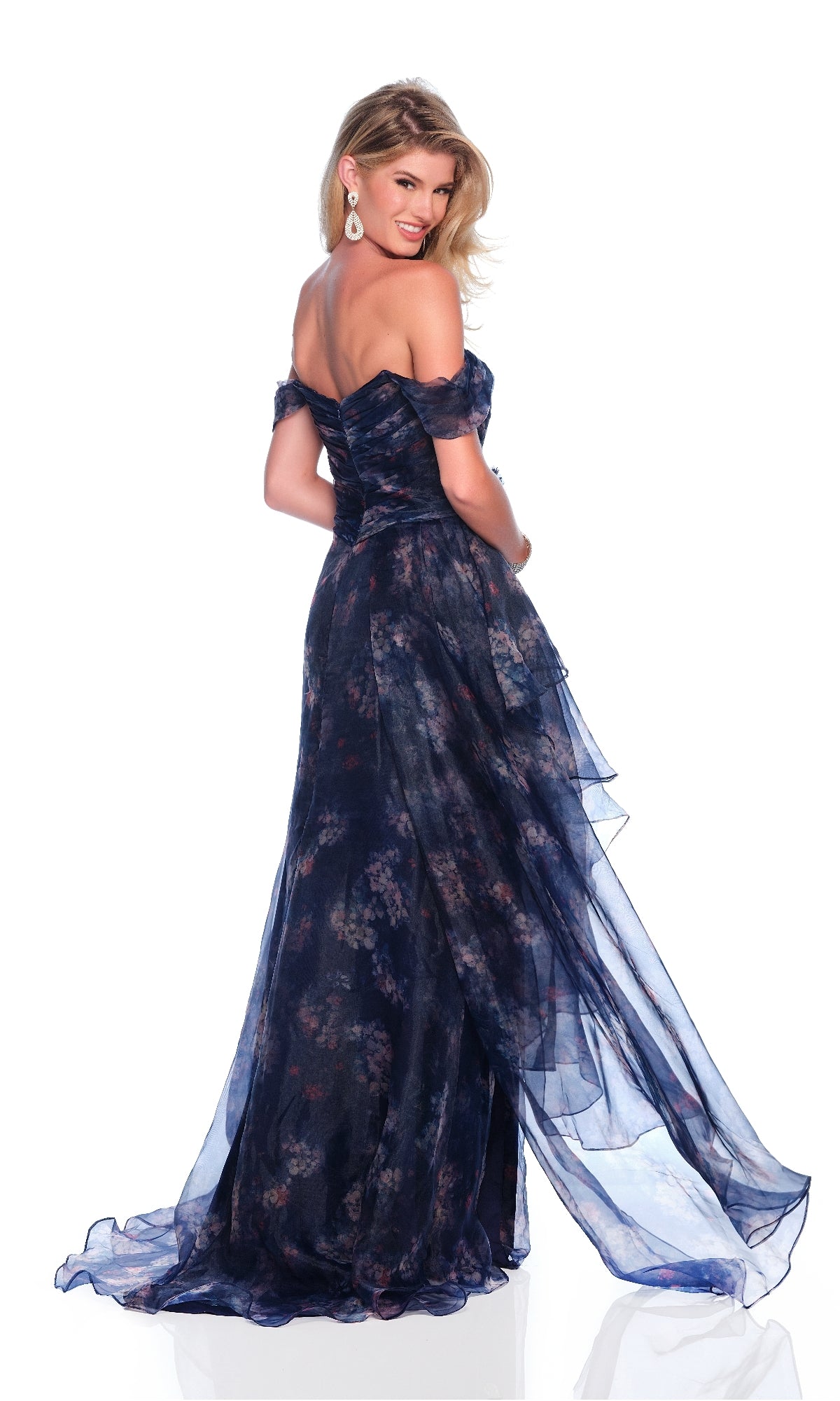 Smiling, a woman poses over her shoulder in the Dave & Johnny 12336 navy floral prom dress, set against a white background.